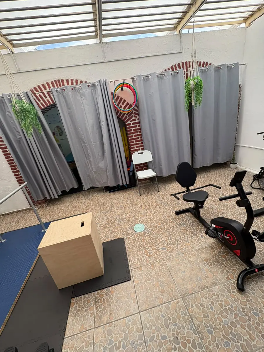 Área de ejercicio con bicicletas y cubículos con cortinas