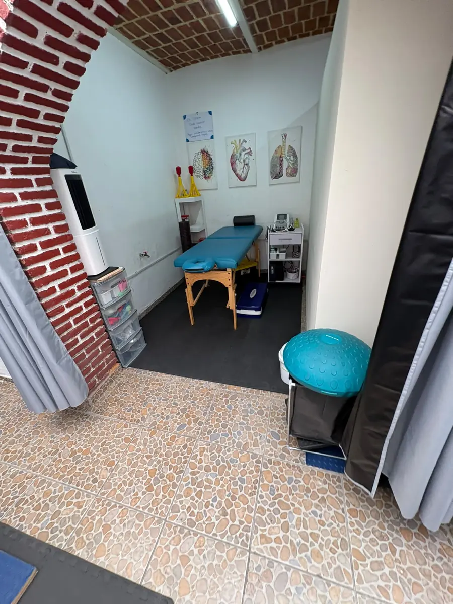 Cubículo de terapia con camilla bajo arco de ladrillo